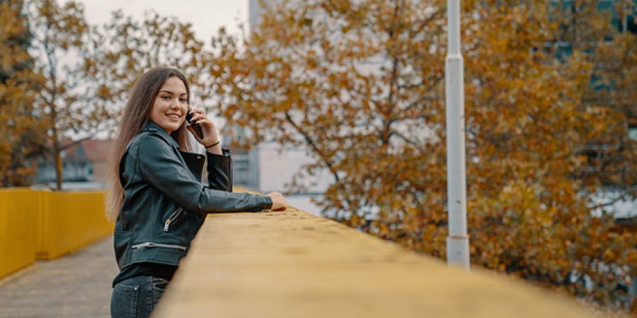 Girl leaning on bannister while calling looking into camera smiling (Horizontal) 2.jpg